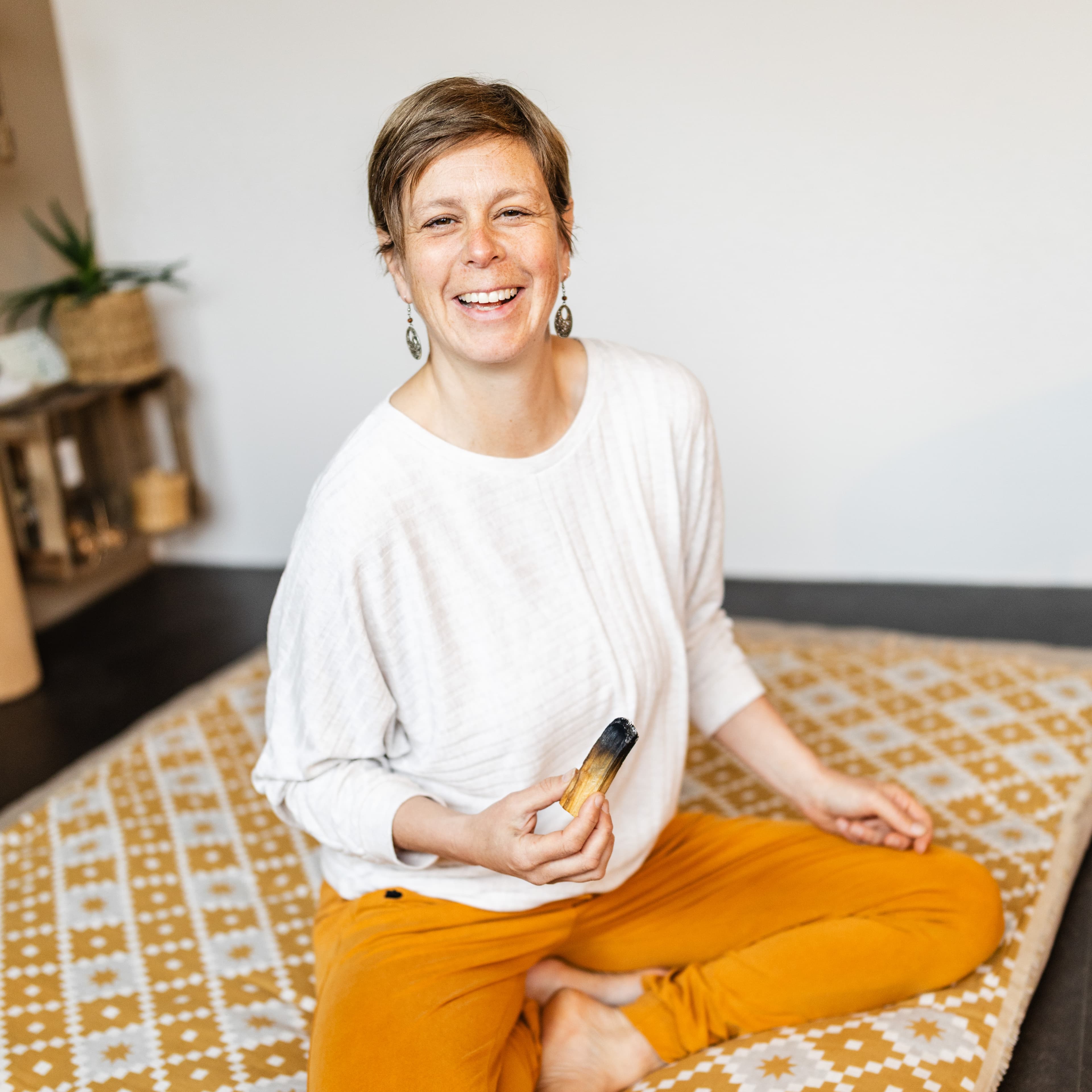 Anne Thorand lachend im Schneidersitz – Bodywork Therapeutin und Yogalehrerin aus Pfaffenweiler bei Freiburg