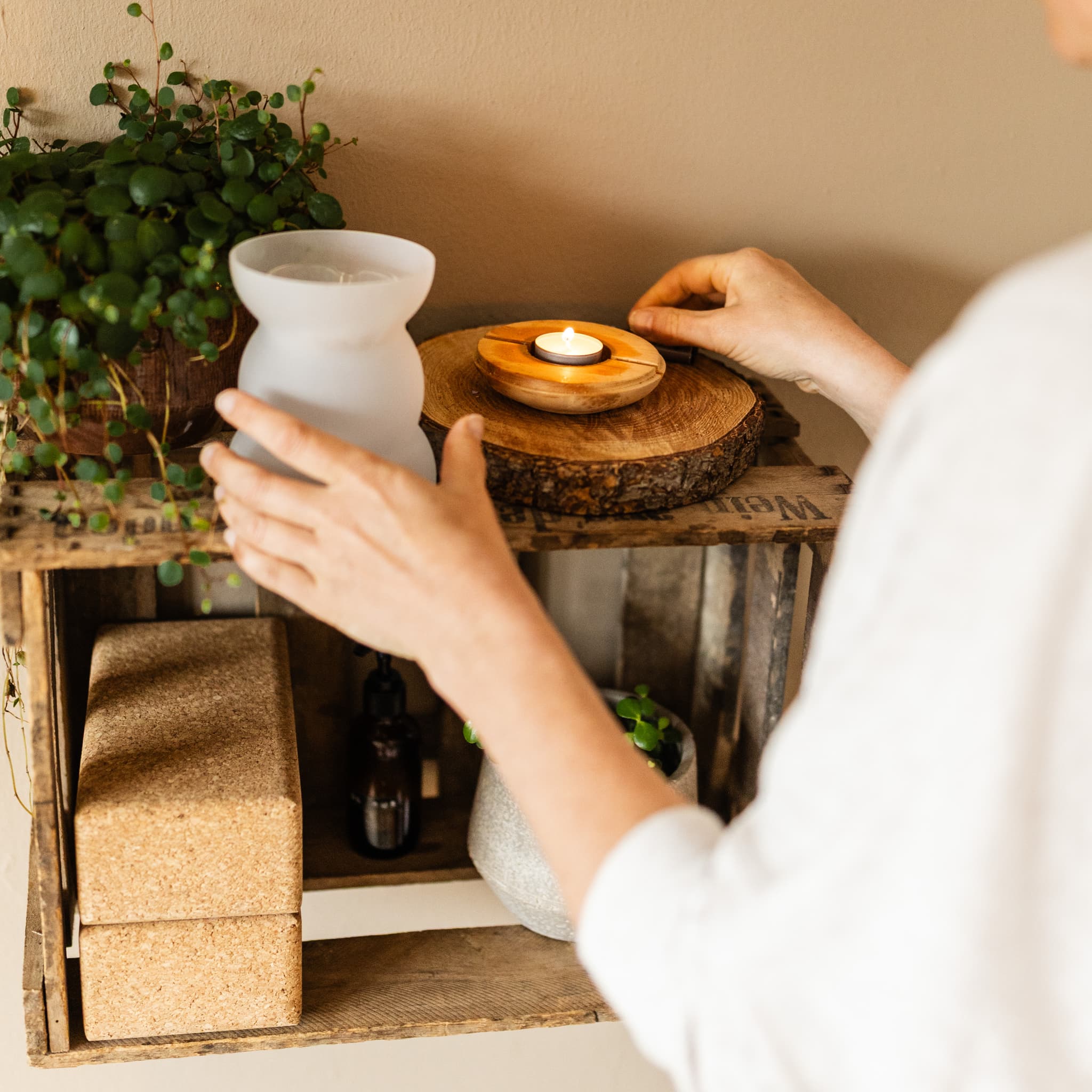 Kerze und Yogablöcke auf Holzregal – achtsamer Raum für Yoga, Atemarbeit und Kakao-Zeremonien Freiburg und online