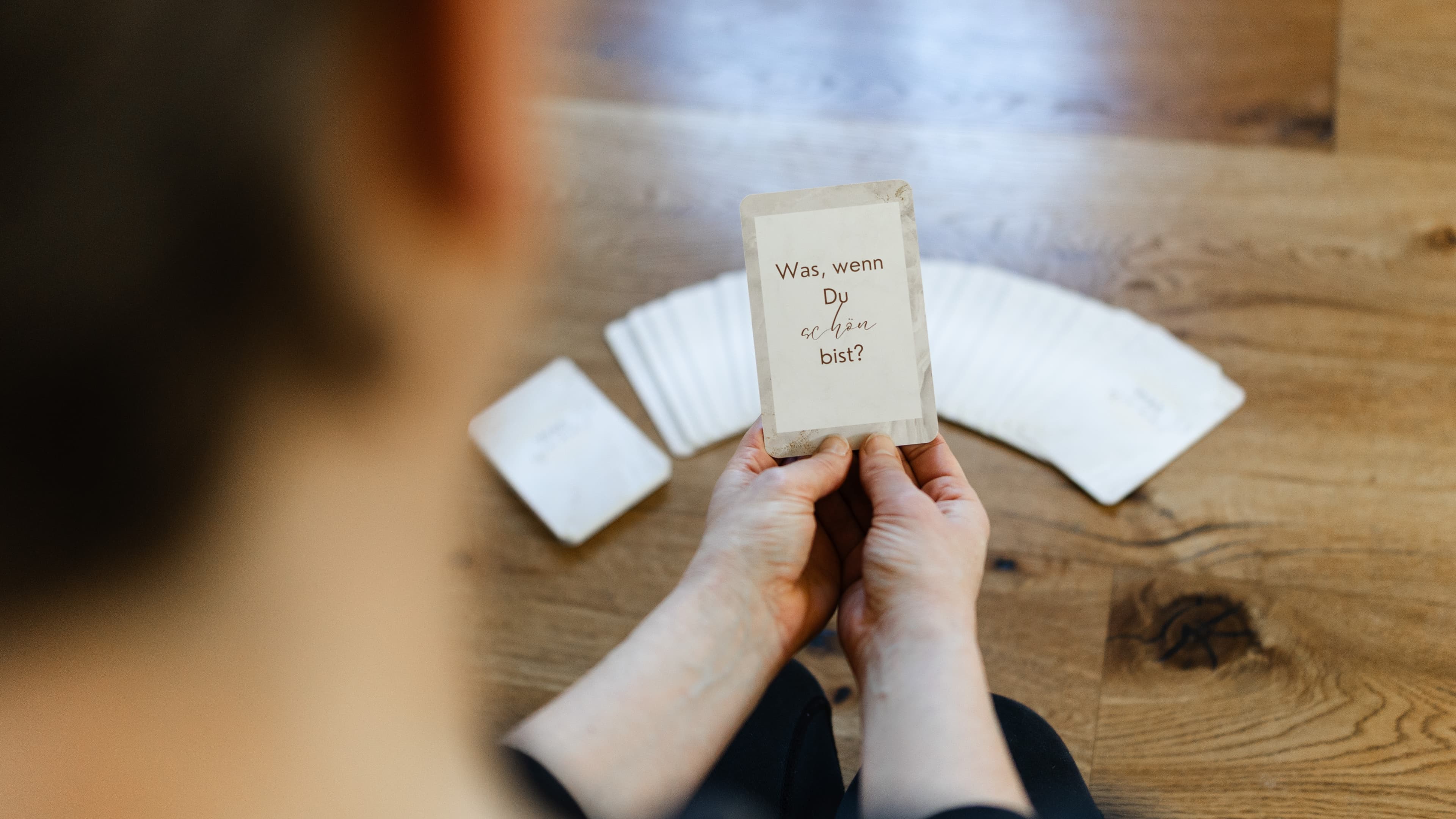 Hände halten eine Reflexionskarte mit der Aufschrift: Was, wenn Du so schön bist? – somatisches Coaching Freiburg