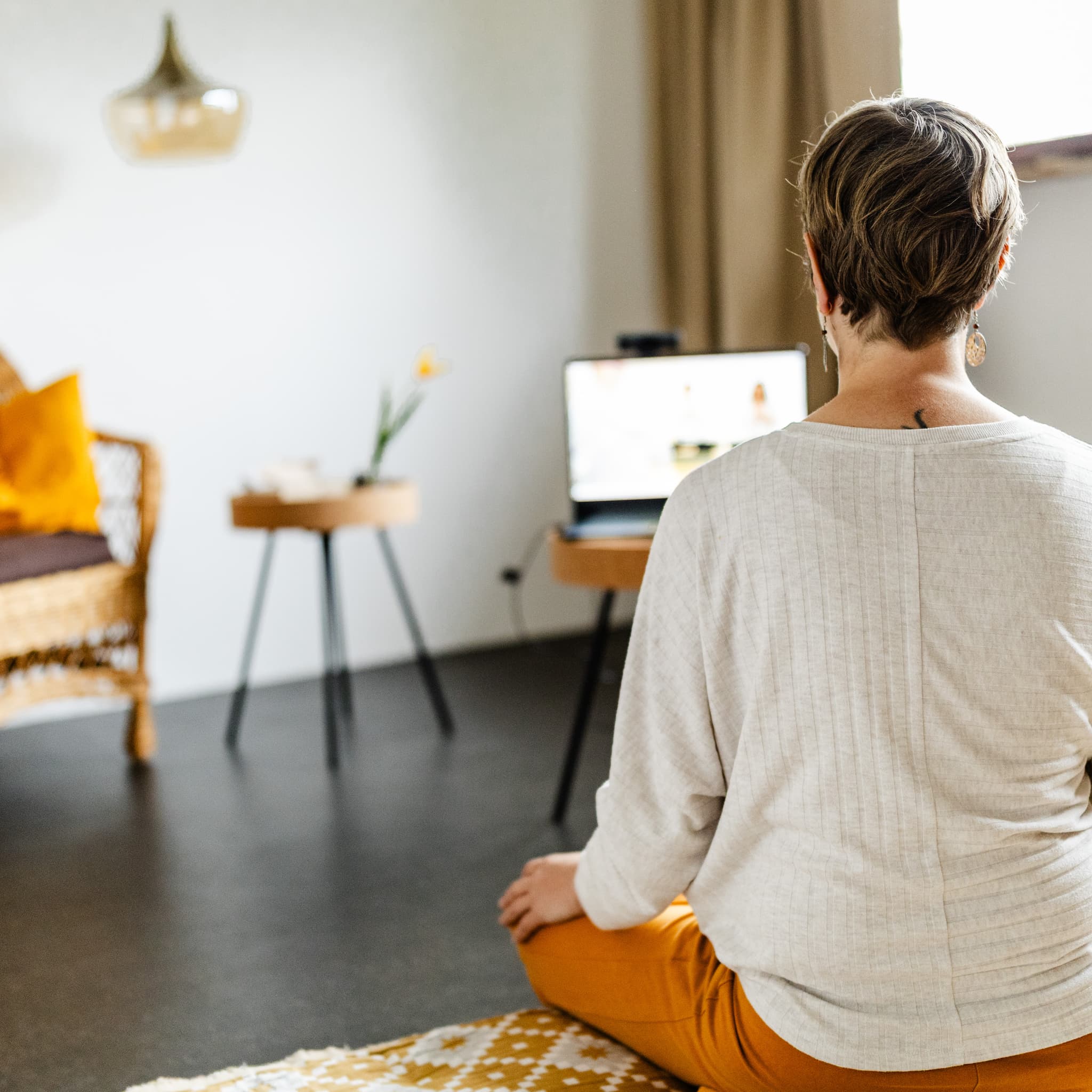 Anne Thorand vor Laptop im Schneidersitz – somatisches Coaching und Yoga online von zuhause