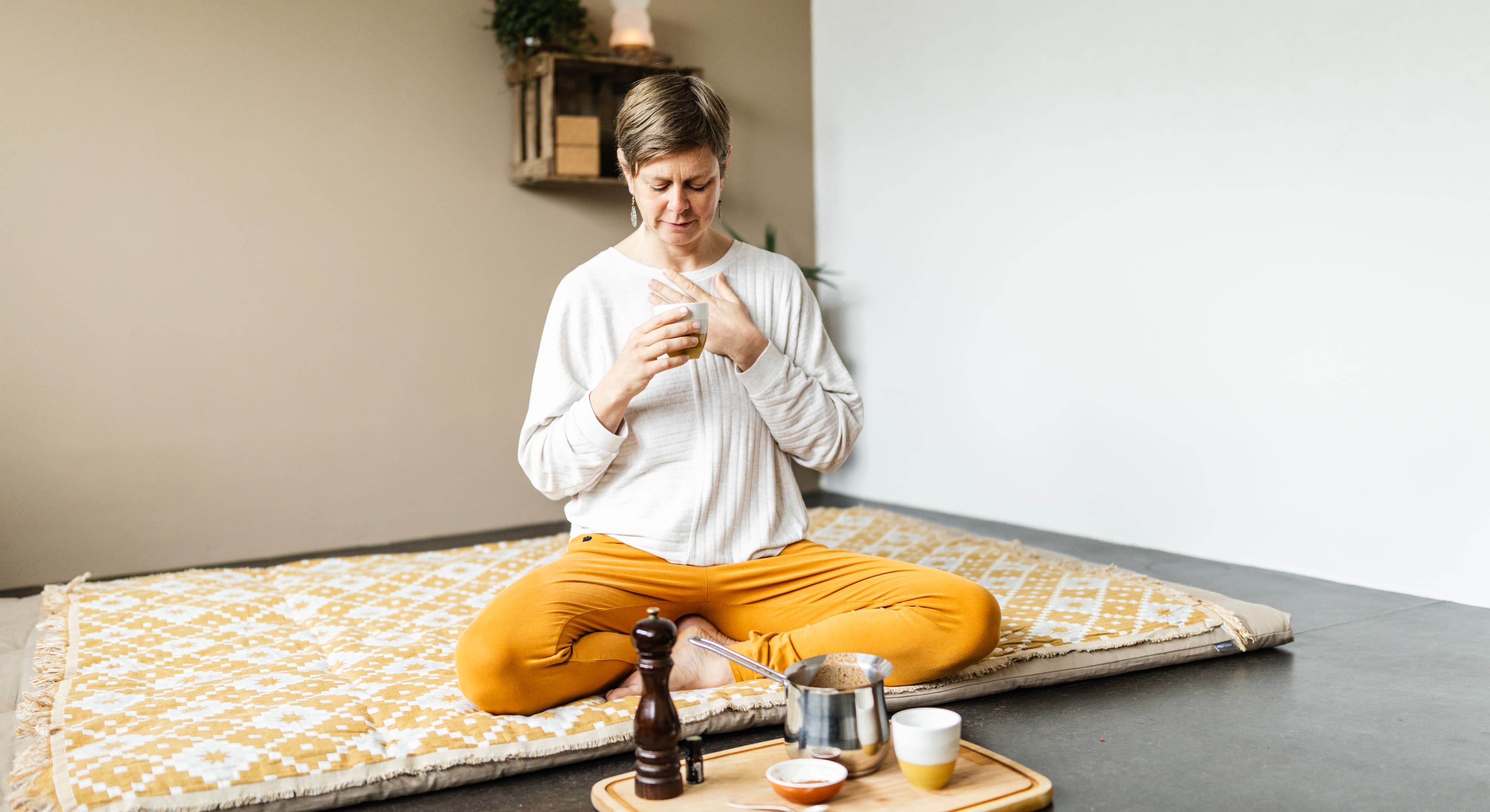 Frau sitzt meditierend im Schneidersitz – Awaken Your Inner Mentor, Online-Kurs für Nervensystemregulation Freiburg